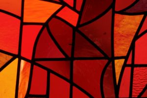 A photo of red and orange stained glass.