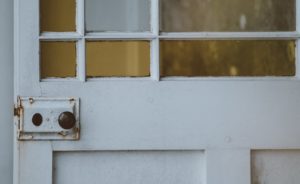 Image of a white door with a rusty door knob