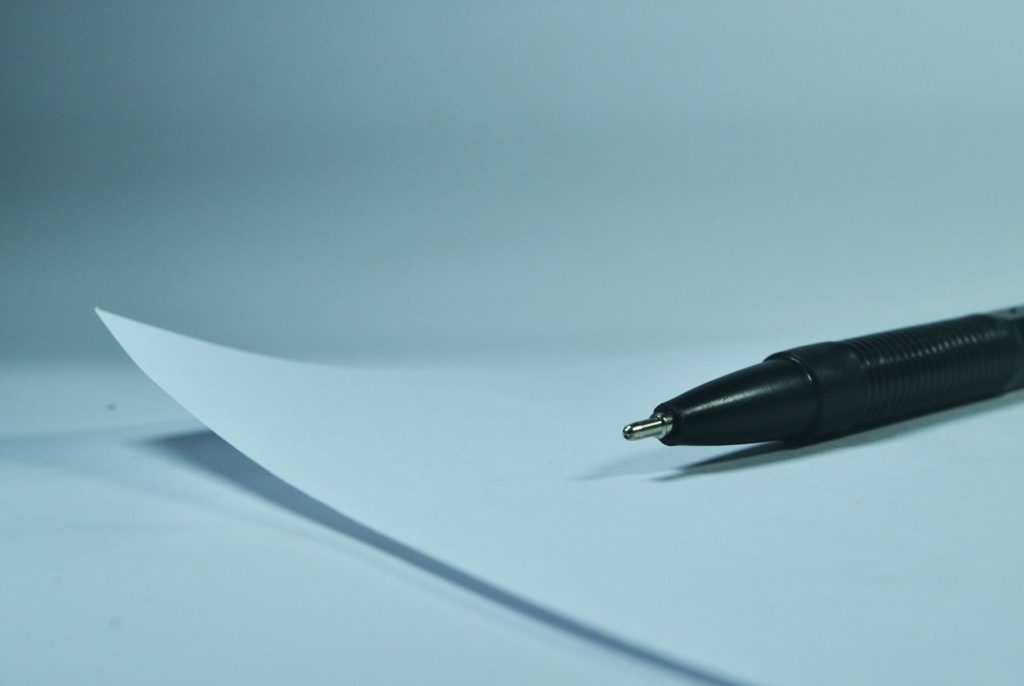 Photo of a white paper and a black pen lying on top of it