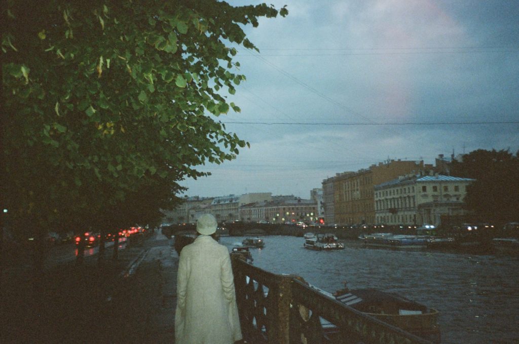 Picture of the back of a white-clad walking down a bridge