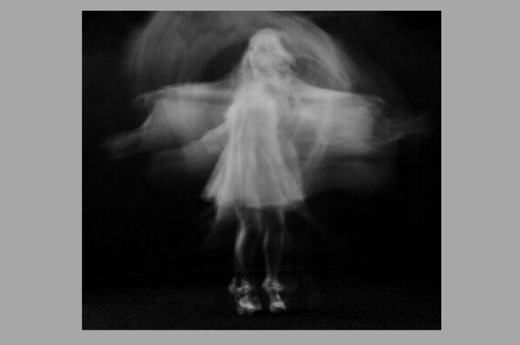 Black and white image of ghostly girl on black background