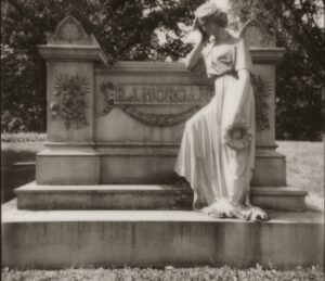 black and white photo of a tombstone with a statue of a woman