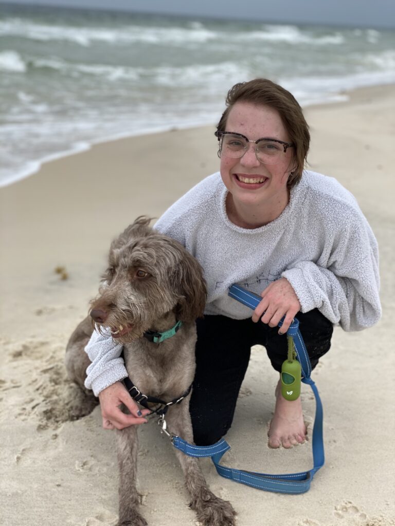 Photo of author holding dog at the beach.